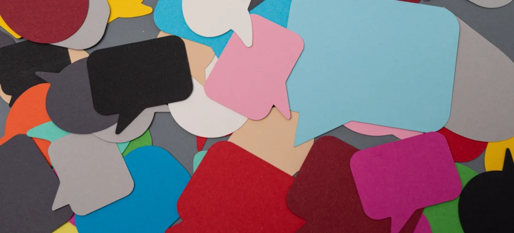 Bunte Sprechblasen aus Papier, gestapelt aufeinander.