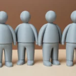 Bunte 3D-gedruckte Figuren nebeneinander. Links eine blaue Figur, rechts eine rote, dazwischen mehrere Graue: Symbol für gegensätzliche ideologische Lager.